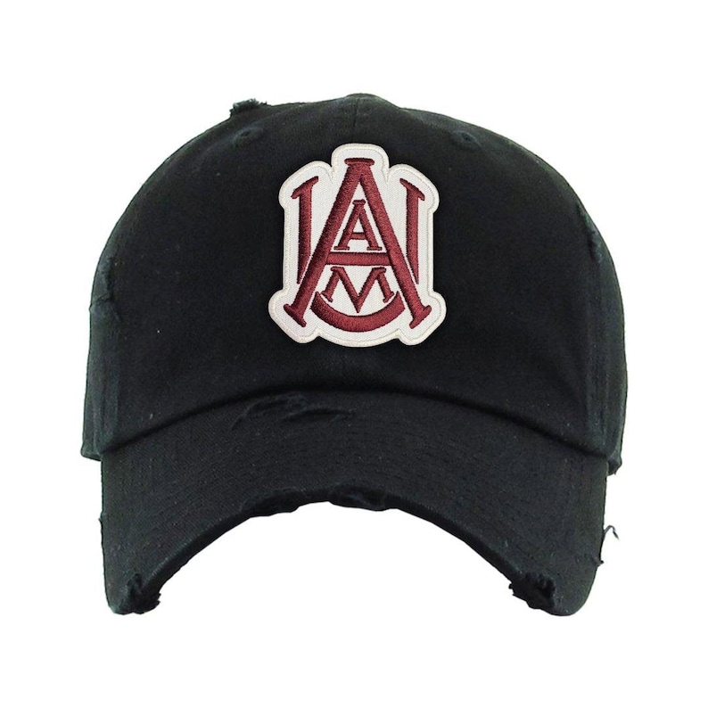 May include: Black distressed baseball cap with a maroon and white embroidered patch featuring the letters "A" and "M". The cap has a curved brim and a worn, vintage look.