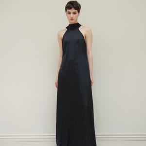May include: A black halter-neck maxi dress with a simple, sleek design.