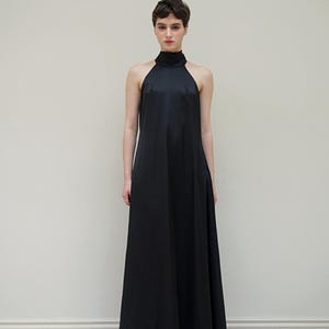 May include: A black halter-neck maxi dress with a simple, sleek design.