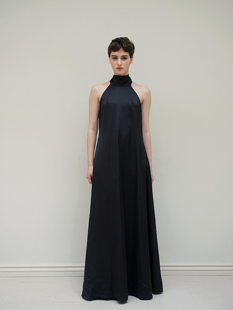 May include: A black halter-neck maxi dress with a simple, sleek design.
