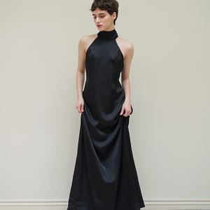 May include: A black halter-neck maxi dress with a high neckline and a flowing skirt.