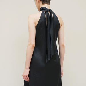 May include: A black halter dress with a long, flowing skirt and a black satin ribbon tied at the neck.