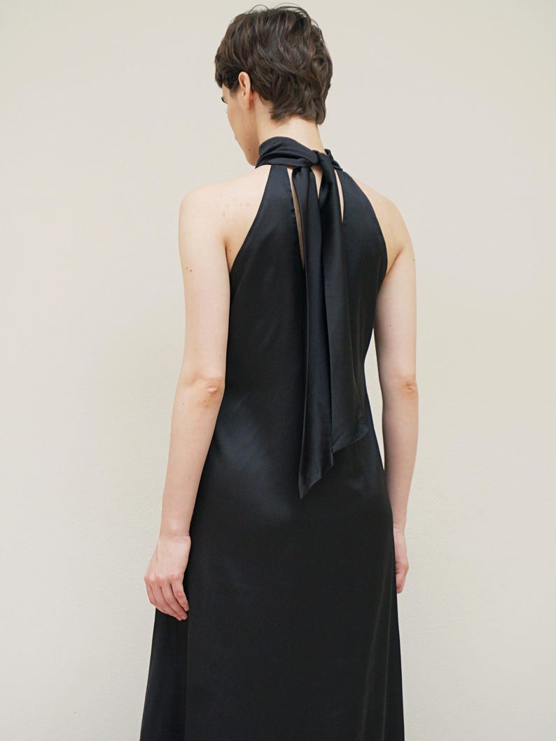 May include: A black halter dress with a long, flowing skirt and a black satin ribbon tied at the neck.