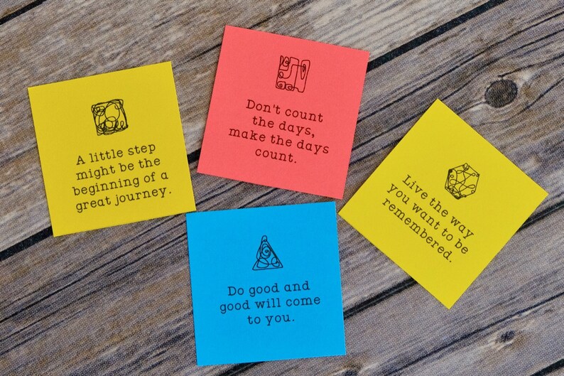 May include: Four yellow and blue sticky notes with inspirational quotes and doodles on a wooden surface. The quotes are: "A little step might be the beginning of a great journey." "Don't count the days, make the days count." "Do good and good will come to you." "Live the way you want to be remembered."
