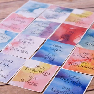 May include: A set of colourful affirmation cards with watercolour backgrounds. Each card features a positive message, such as "Choose Love over Resentment" and "Choose Happiness over Sadness".