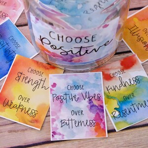 May include: A set of colourful cards with watercolour backgrounds and inspirational messages. Each card features the phrase "Choose" followed by a positive affirmation, such as "Choose Strength over Weakness" or "Choose Kindness over Resentment".