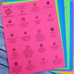 May include: A stack of colorful cards with positive messages printed on them. The cards are pink, orange, yellow, green, blue, and light blue. The messages include "Speak kindly to yourself", "Your happiness depends on the quality of your thoughts", "Believe in yourself. You have everything you need to accomplish what you want", "Never say "I can't". Always say "I'll try."