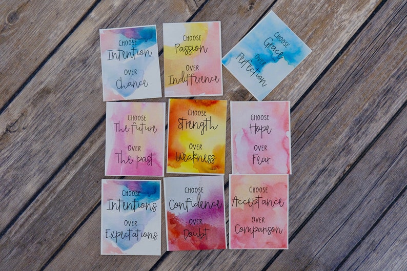 May include: Nine watercolour cards with inspirational quotes. Each card features a different colour scheme and a quote about choosing a positive mindset. The quotes include "Choose Intention over Chance", "Choose Passion over Indifference", "Choose Grace over Perfection", "Choose the Future over the Past", "Choose Strength over Weakness", "Choose Hope over Fear", "Choose Intentions over Expectations", "Choose Confidence over Doubt", and "Choose Acceptance over Comparison".