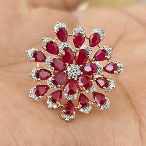 Anillo de compromiso floral con rubí en oro de 14 quilates y detalles de diamantes naturales.