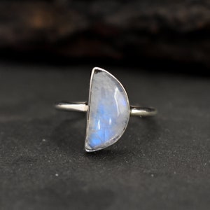 Può includere: Un anello d'argento con una pietra di luna a forma di mezzaluna.