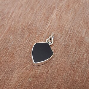 May include: A black onyx pendant in a silver shield shape.