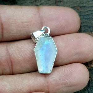 Op de afbeelding: Een zilveren hanger met een grote, iriserende maansteen in de vorm van een kist.