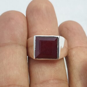 Peut inclure: Une bague en argent avec une pierre carr&eacute;e rouge fonc&eacute;.