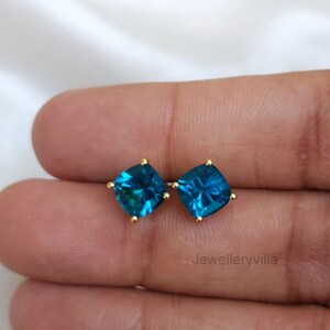 Puede incluir: Un par de pendientes de bot&oacute;n de oro con piedras preciosas azul turquesa de forma cuadrada.