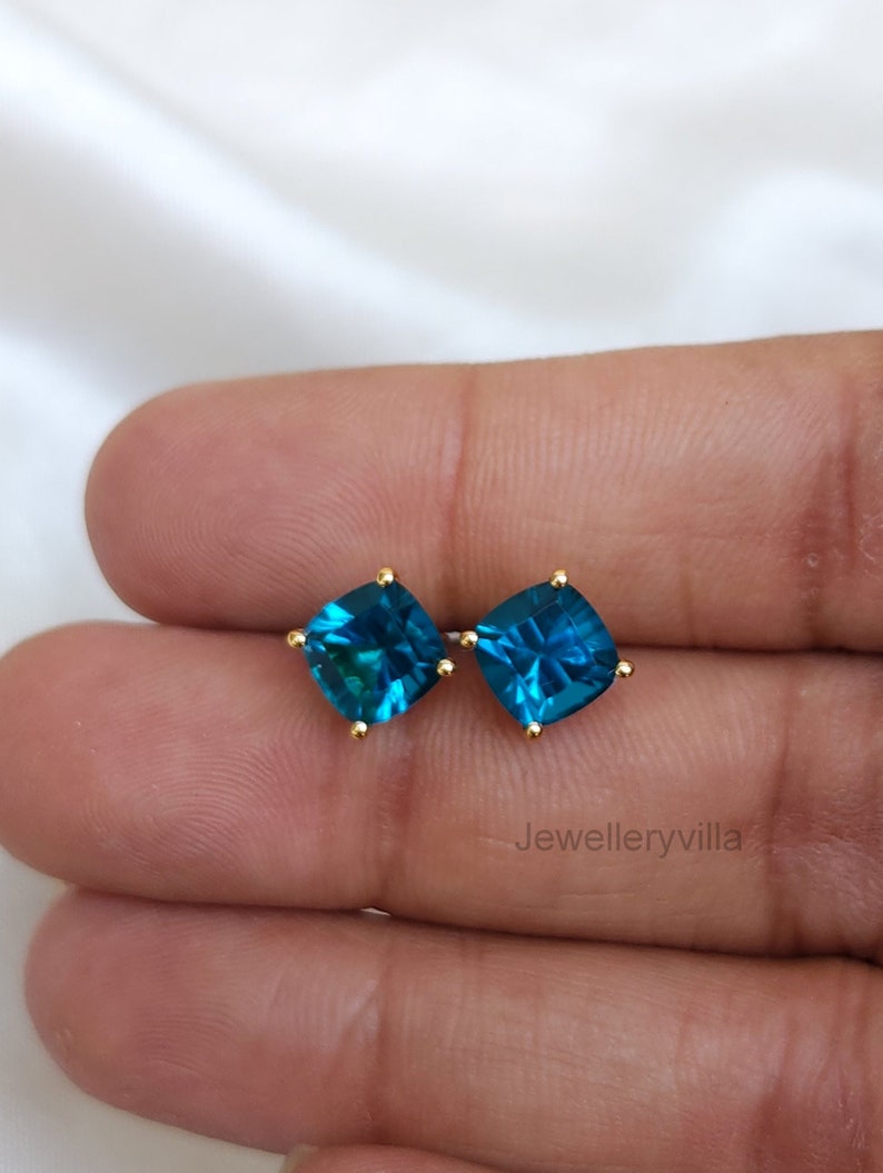 Puede incluir: Un par de pendientes de bot&oacute;n de oro con piedras preciosas azul turquesa de forma cuadrada.