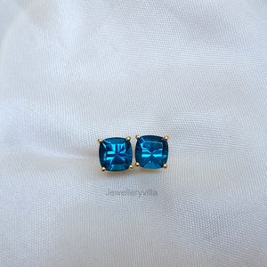 Puede incluir: Un par de pendientes cuadrados con piedras preciosas azules engastadas en oro.