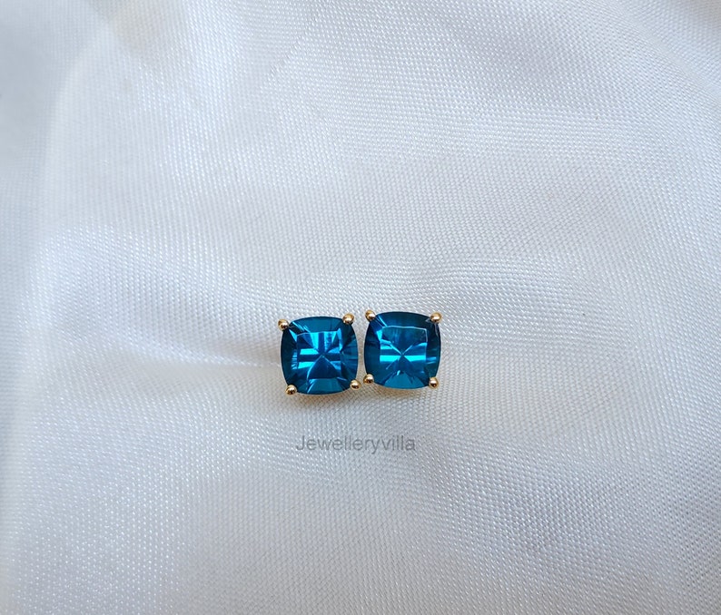 Puede incluir: Un par de pendientes cuadrados con piedras preciosas azules engastadas en oro.