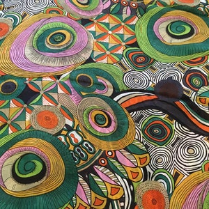 May include: Abstract fabric with a colourful pattern of circles, swirls, and geometric shapes in shades of green, orange, pink, and black.