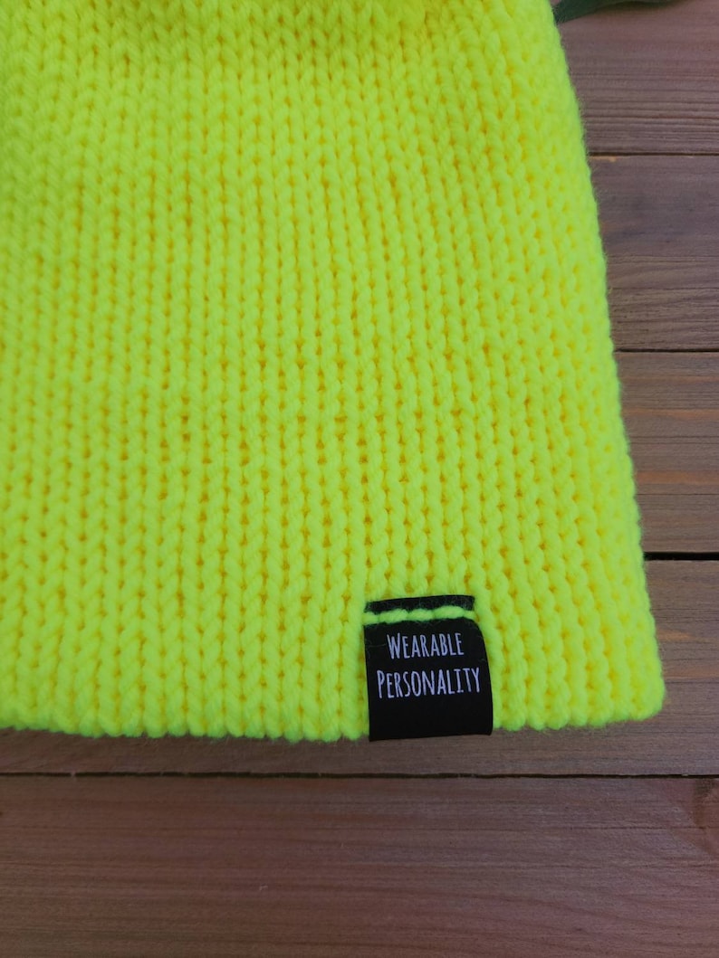 May include: A bright yellow knitted beanie with a black label that reads "Wearable Personality".