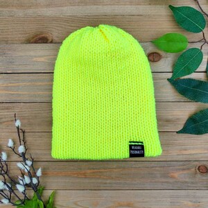 May include: A bright neon yellow knitted beanie with a black label that reads "Wearable Personality".