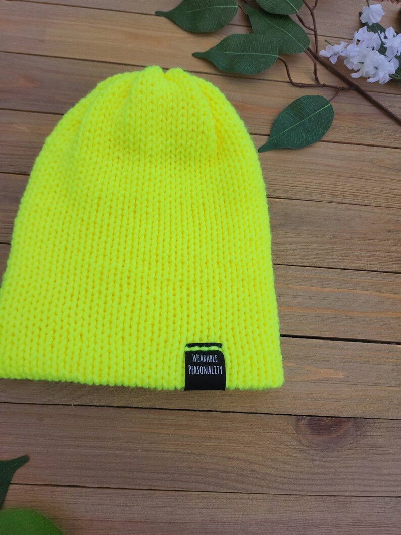 May include: A bright yellow knitted beanie with a black label that reads "Wearable Personality".
