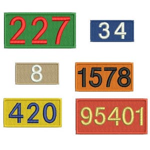 Op de afbeelding: Geborduurde patches in verschillende kleuren, elk met een ander nummer. De patches tonen de nummers 227, 34, 8, 1578, 420 en 95401. De patches zijn rechthoekig en hebben een gestikte rand.