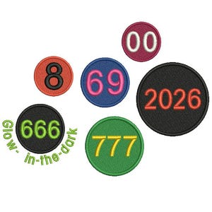 Op de afbeelding: Een verzameling geborduurde patches in verschillende kleuren, elk met een ander nummer. De patches bevatten de nummers 8, 69, 00, 2026, 666 (met de tekst "glow-in-the-dark") en 777. De patches zijn cirkelvormig.