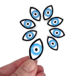 以下が含まれることがあります： 黒い輪郭のある青と白の邪悪な目のパッチが8つ。パッチは円形に配置され、中央に1つのパッチがあります。