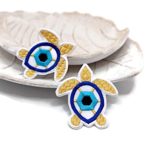 Embroidered sea Turtle with evil eye patch.