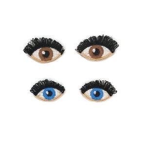 May include: Four embroidered iron-on patches of eyes with eyelashes. Two patches have brown eyes and two patches have blue eyes.