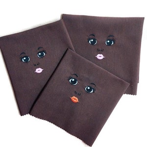 Embroidered face for African rag doll.