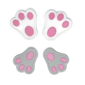 Può includere: Quattro toppe termoadesive a forma di zampa. Due sono bianche con cuscinetti rosa e due sono grigie con cuscinetti rosa.