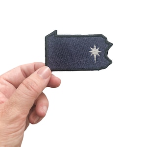 May include: A dark blue embroidered patch shaped like the state of Pennsylvania with a white star in the center.