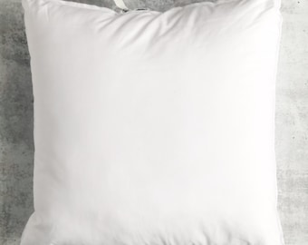 May include: A white pillow with a white zipper closure. The pillow is on a gray textured surface.