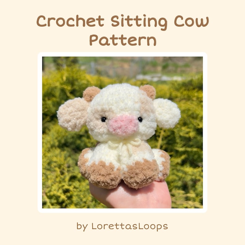 May include: Crocheted sitting cow amigurumi toy with white and brown fur, pink nose, and black eyes. The toy is sitting on a hand against a green background. The image text reads "Crochet Sitting Cow Pattern by LorettasLoops".