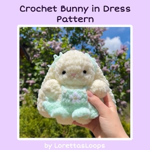 May include: A fluffy, cream-colored crochet bunny wearing a mint green dress with a flower detail. The image includes the text "Crochet Bunny in Dress Pattern" and "by LorettasLoops". The bunny has black eyes and a light pink nose.