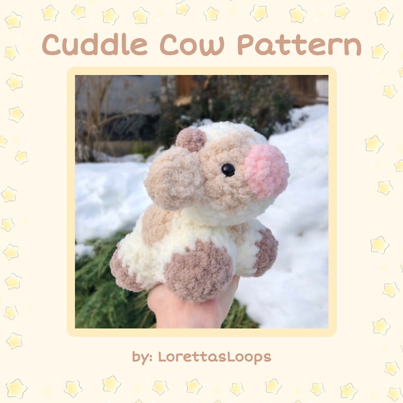 May include: A crocheted plush cow toy with brown and white fur, pink ears, and black eyes. The toy is being held in a hand against a snowy background. The text "Cuddle Cow Pattern by: LorettasLoops" is visible at the top and bottom of the image.