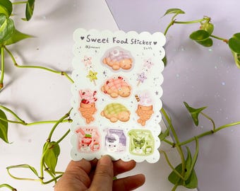 May include: A sheet of Sweet Food Stickers featuring cute illustrations of turtle-shaped pastries, fish-shaped ice cream cones, and milk carton characters. The stickers are in pastel colors with a scalloped edge and the text "Sweet Food Sticker" at the top.