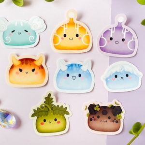 Puede incluir: Una colección de pegatinas coloridas, troqueladas, con adorables criaturas de dibujos animados con forma de mancha. Cada pegatina tiene un diseño único, incluyendo motivos de nubes, llamas y plantas, con expresiones faciales lindas.