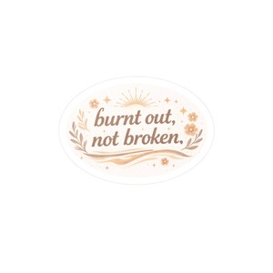 May include: An oval sticker with the text "burnt out, not broken" in a brown, elegant font. The design includes floral and sunburst elements in shades of brown and beige, creating a calming aesthetic.