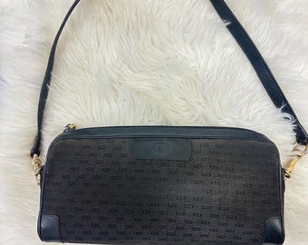 May include: Black leather shoulder bag with a gold chain strap and a GG monogram pattern.
