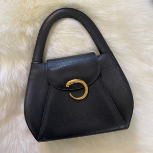Bolso de noche con asa superior Cartier Panthère vintage de los años 90, de piel de caviar negra y dorada con diseño de pantera.
