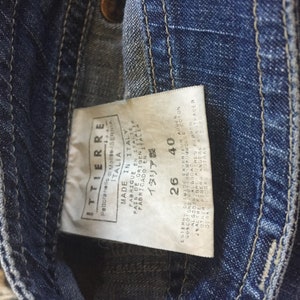 May include: A blue denim jean label with white text that reads "ITTIERRE", "Pettoranello di Molise", "ITALIA", "MADE IN ITALY", "PARRICUP EN ITALTE", "FABRICADO EN ITAL", "PAIS OF ORIGENLEICA", "ITALIA", "26", "40".