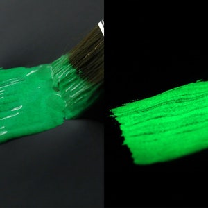 May include: A green paint brush stroke glows brightly in the dark, demonstrating the paint's glow-in-the-dark properties.