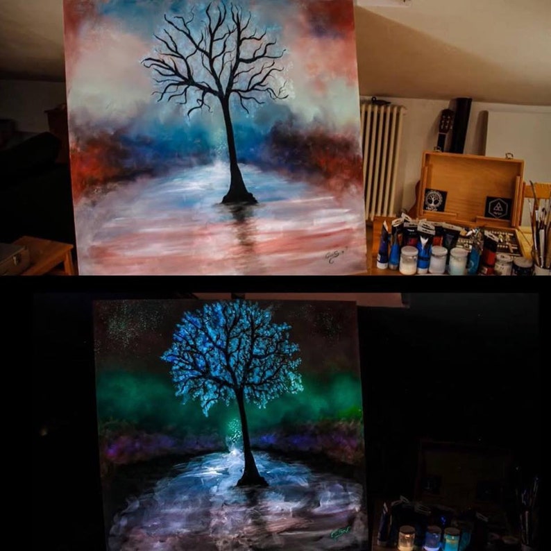 May include: A painting of a tree with blue and white branches, standing in a body of water. The painting glows in the dark, with the tree and water glowing a bright blue and green.