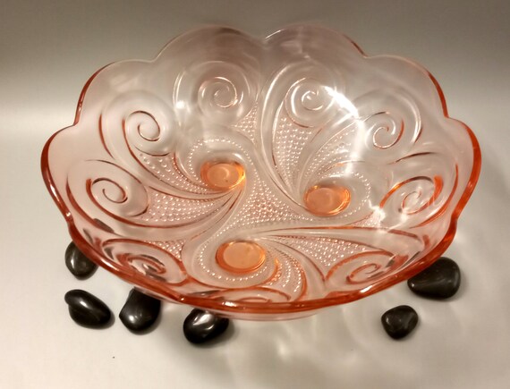 Beautiful pink glass serving dish with swirl patterns and scalloped edge. Three-legged pressed glass salad bowl