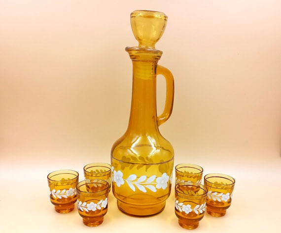 Old liquor service in colored glass, vintage amber yellow carafe