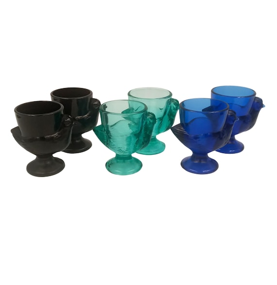 Vintage French glass egg cups in the shape of a hen, blue, green and black