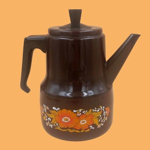 May include: A brown enamel coffee pot with a floral design in orange, yellow, and white. The pot has a black handle and a black lid.