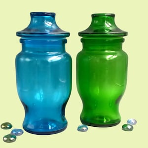 Pair of turquoise blue and emerald green glass POTs, jars with airtight pagoda caps, lever
